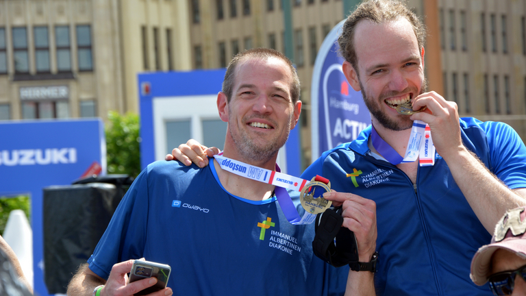 Zwei Teilnehmer mit Medaille beim Zieleinlauf World Triathlon Sprint & Relay Championships in Hamburg